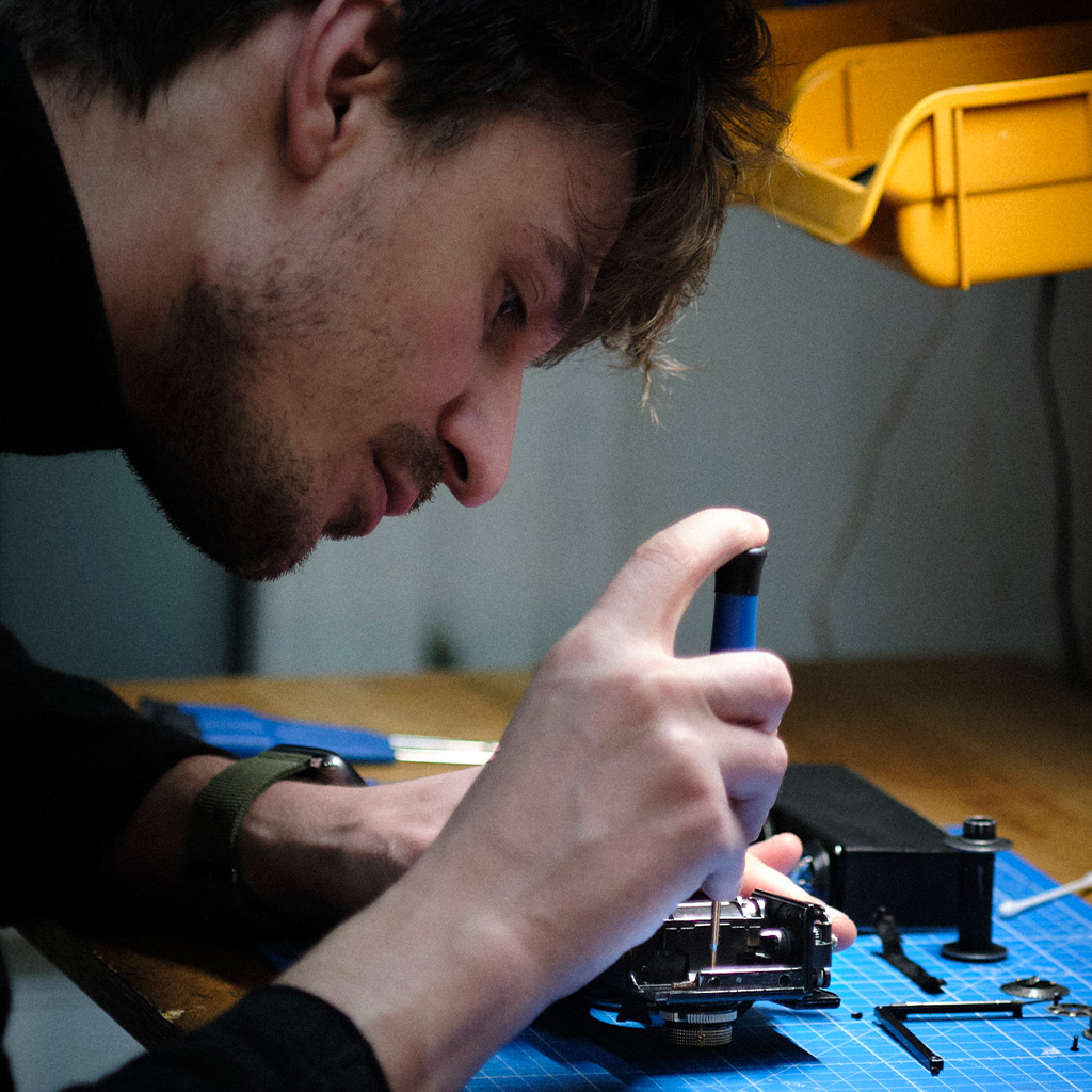 Hadrien Simeray répare un appareil photo argentique à l'atelier